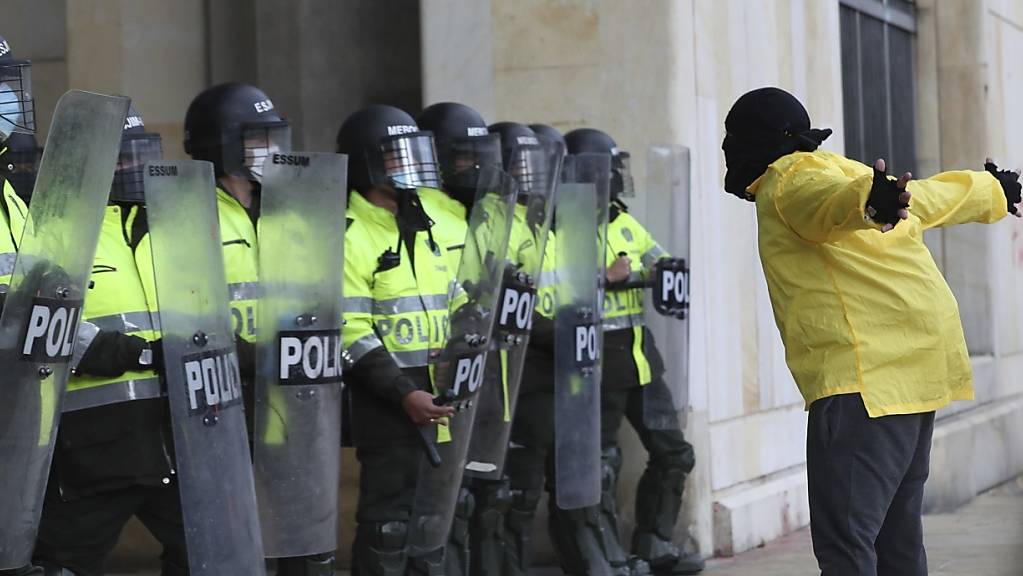 Ein Demonstrant steht während eines Protests gegen die Regierung vor Polizisten. Foto: Fernando Vergara/AP/dpa