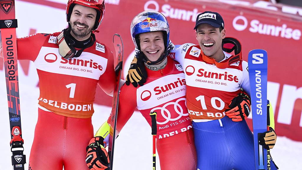 Marco Odermatt (Mitte) feiert seinen vierten Riesenslalomsieg in Adelboden mit dem zweitplatzierten Loïc Meillard (links) und dem drittplatzierten Luca De Aliprandini