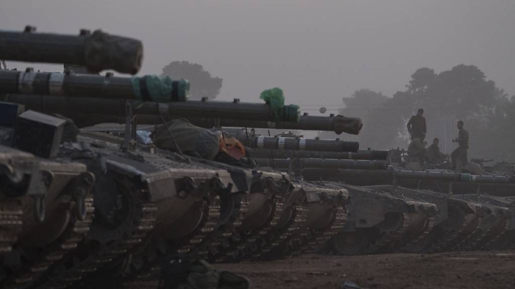 Israelische Soldaten stehen auf einem Panzer in einem Bereitstellungsbereich an der Grenze zwischen Israel und Gaza. Foto: Leo Correa/AP/dpa