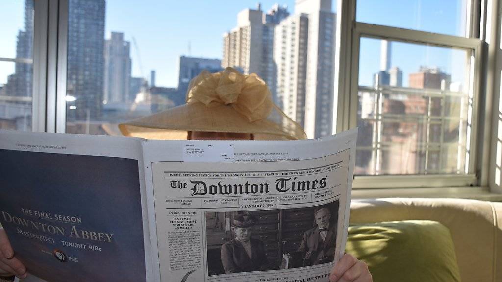 Eine Frau liest am Sonntag in New York «The Downton Times» (Symbolfoto). Das Doppelblatt ist eine Werbeaktion, mit der die «New York Times» als Zeitung von 1925 verkleidet wurde, um für den Start der letzten Staffel der TV-Serie «Downton Abbey» zu werben.