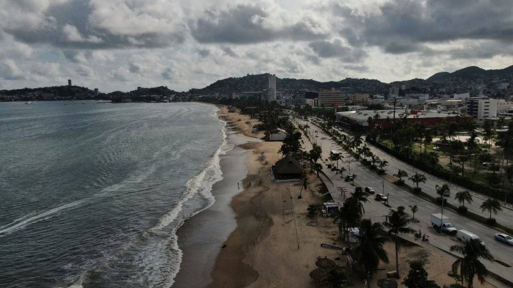 dpatopbilder - Touristen schlendern vor dem Eintreffen des Hurrikans «Erick» am Strand entlang. Foto: Fernando Llano/AP/dpa