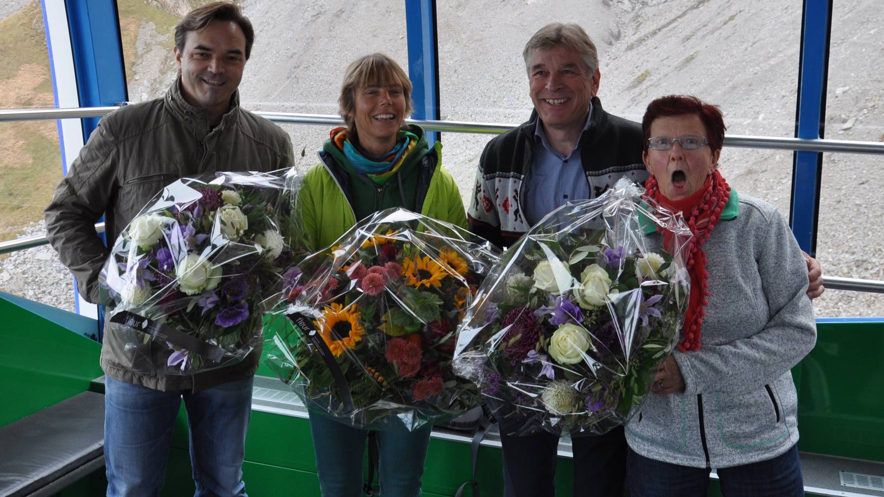Blumen für die 25 Millionste Besucherin Ursula Baumberger (in grün)  und die beiden Fahrgäste vor und nach der Jubiläumsmarke