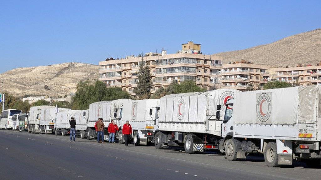 UNO-Camions stehen in Damaskus vor der Abfahrt in die belagerten Städte. Ein Konvoi hat sein Ziel bisher erreicht.