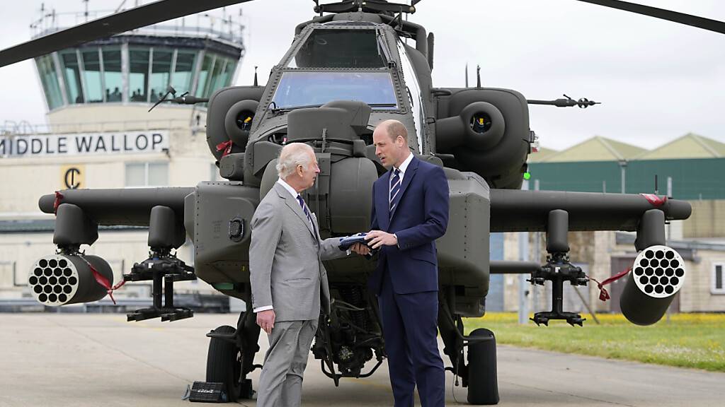 Großbritanniens König Charles III. übergibt offiziell das Amt des Oberst des Army Air Corps an Prinz William vor einem Apache-Hubschrauber im Army Aviation Centre. Foto: Kin Cheung/AP POOL/AP/dpa