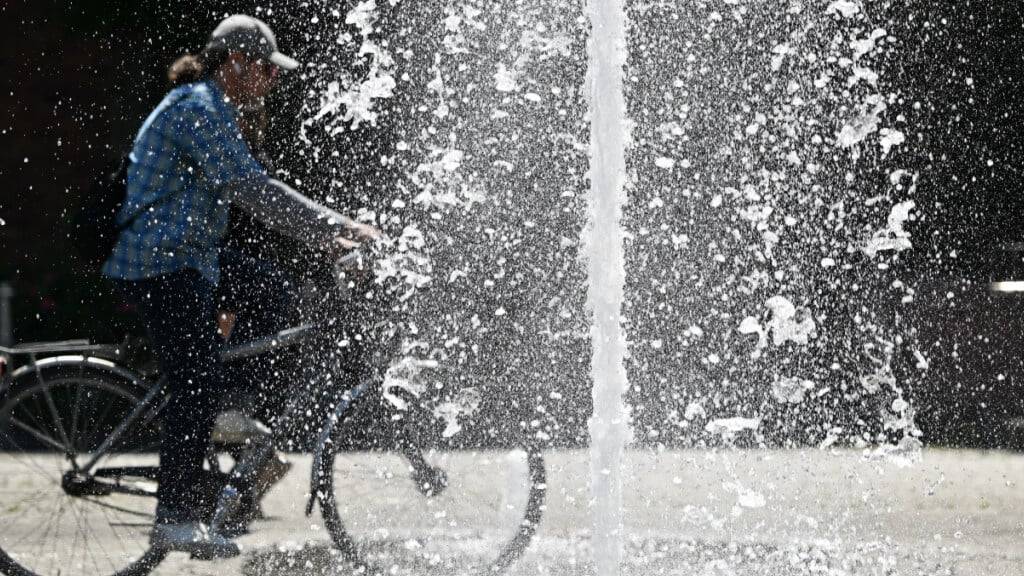 ARCHIV - Ein Radfahrer fährt bei sonnigem Frühsommerwetter an den Wasserspielen am Walther von Cronberg-Platz im Ortsteil Sachsenhausen in Frankfurt Am Main in Deutschland vorbei. Foto: Arne Dedert/dpa