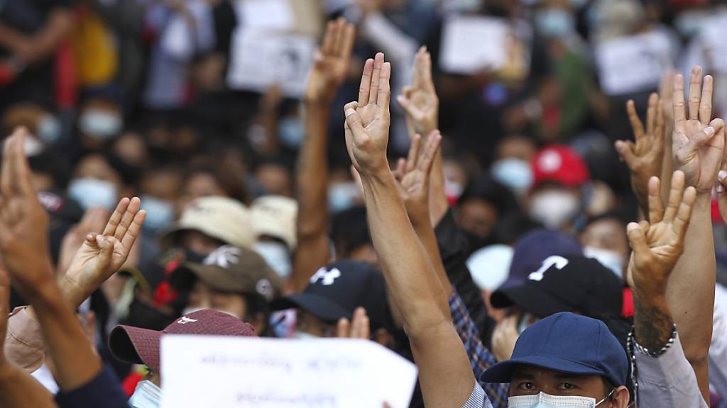 Demonstranten zeigen den Dreifingergruß während ihres Protestmarsches. Sie forderten die Freilassung der politischen Führung und die Rückkehr zur Demokratie. Die Proteste gegen die Putschisten in Myanmar breiten sich weiter aus. Foto: Uncredited/AP/dpa
