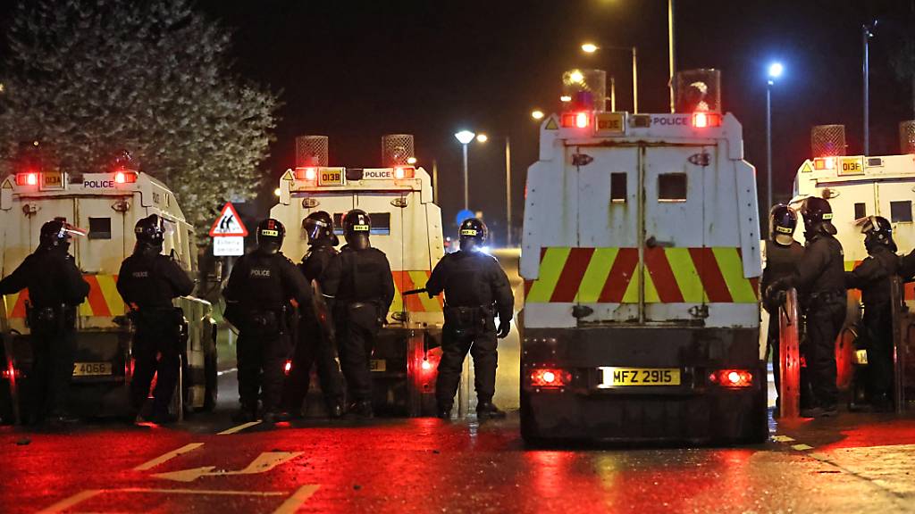 Polizisten stehen nach Unruhen auf einer Straße. In Nordirland ist es in der Osternacht erneut zu gewaltsamen Unruhen gekommen. Foto: Liam Mcburney/PA Wire/dpa