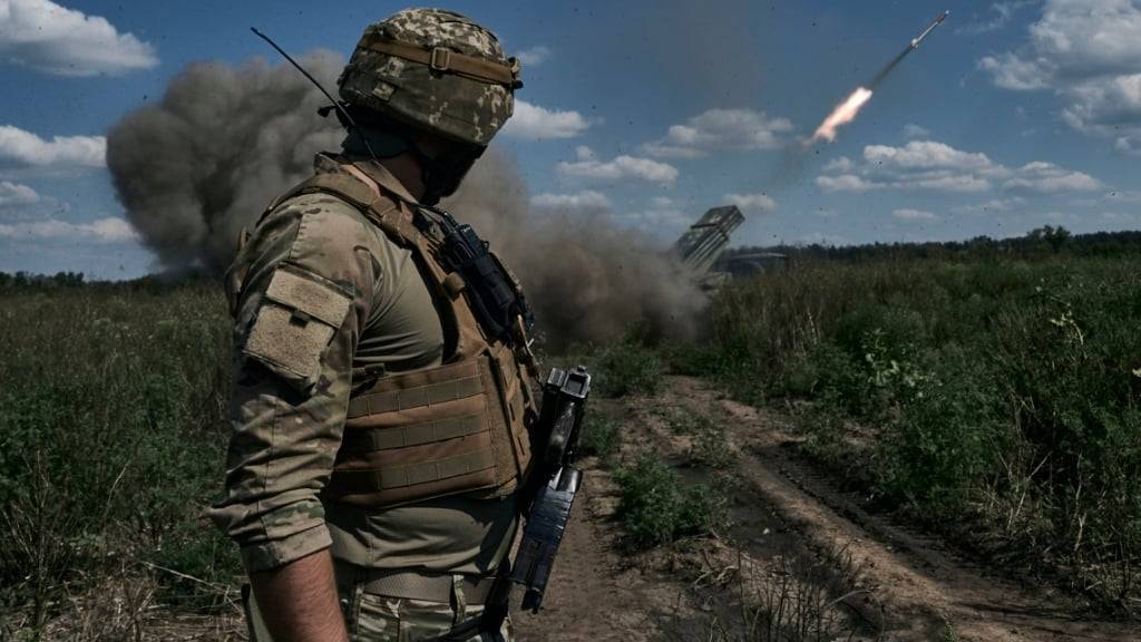 Ein ukrainischer Soldat beobachtet einen Mehrfachraketenwerfer. Foto: LIBKOS/AP/Symbol