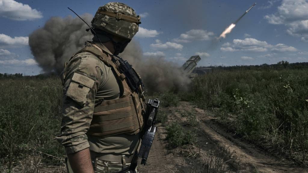 Ein ukrainischer Soldat beobachtet einen Mehrfachraketenwerfer. Foto: LIBKOS/AP/Symbol