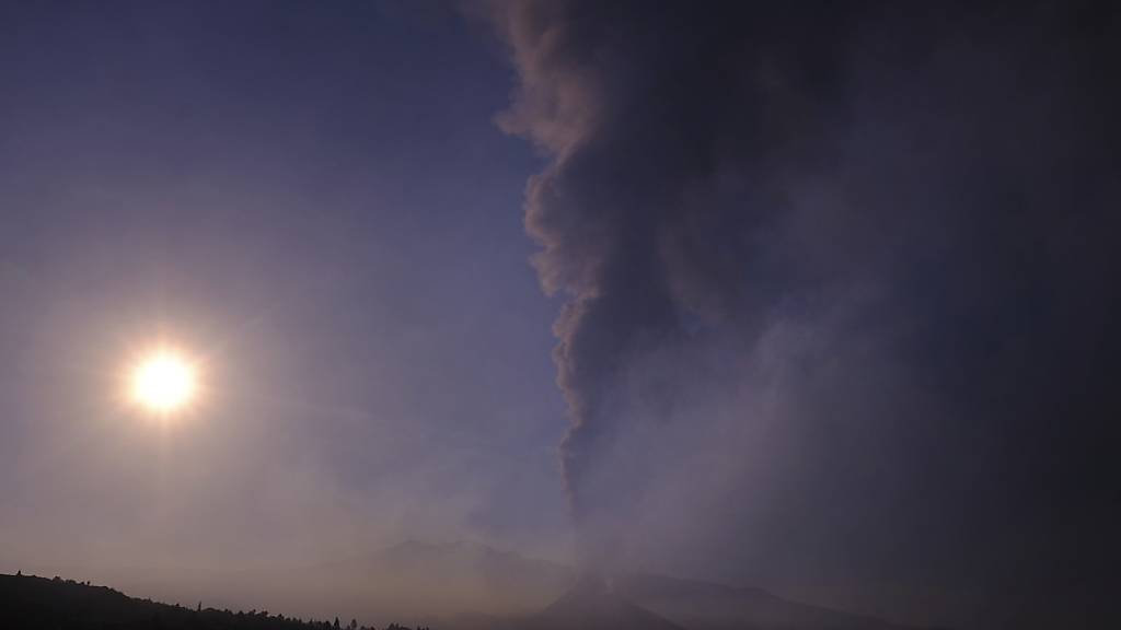 Rauch steigt am Horizont auf, während Lava aus einem Vulkan auf La Palma fließt. Auch die dortige Tourismusbranche leidet unter dem Vulkanausbruch auf der Kanareninsel. Foto: Daniel Roca/AP/dpa