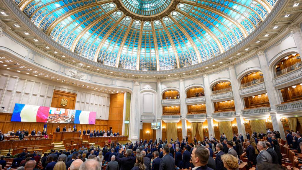 ARCHIV - Rumänische Abgeordnete erheben sich während der Nationalhymne zu Beginn einer Parlamentssitzung im Vorfeld einer Vertrauensabstimmung über die neue Regierung unter der Führung des designierten rumänischen Ministerpräsidenten Muresan. Foto: Andreea Alexandru/AP/dpa