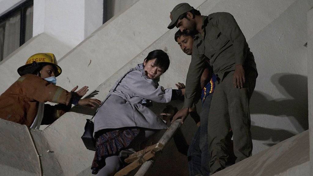 Freiwillige helfen einer Frau einem Feuer zu entkommen in der pakistanischen Stadt Karachi.