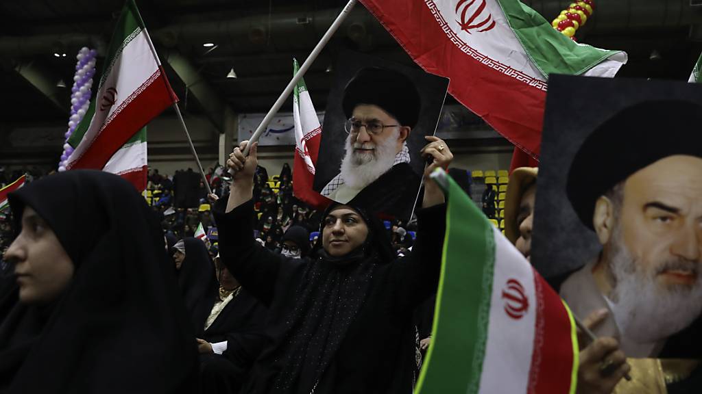 Iranische Frauen schwenken die Fahnen ihres Landes während einer Wahlkampfveranstaltung vor den Parlamentswahlen. Am Freitag wählt der Iran ein neues Parlament und den sogenannten Expertenrat. Foto: Vahid Salemi/AP/dpa