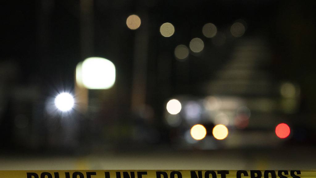 Polizisten untersuchen hinter dem Absperrband weiterhin den Tatort eines Schusswaffenangriffs in der Schemengees Bar and Grille in Lewiston, Maine, zwei Tage nach den Schüssen. Foto: Matt Rourke/AP/dpa