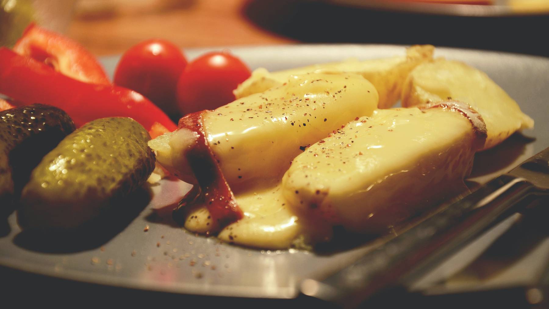So kennen wir es: Das klassische Schweizer Raclette mit Kartoffeln, Essiggurken und ganz viel Käse.