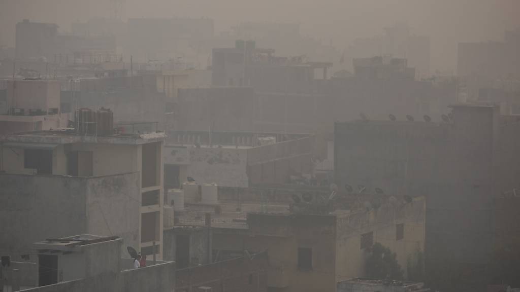 Morgendlicher Dunst und Smog hängt über der Stadt. Foto: Altaf Qadri/AP/dpa