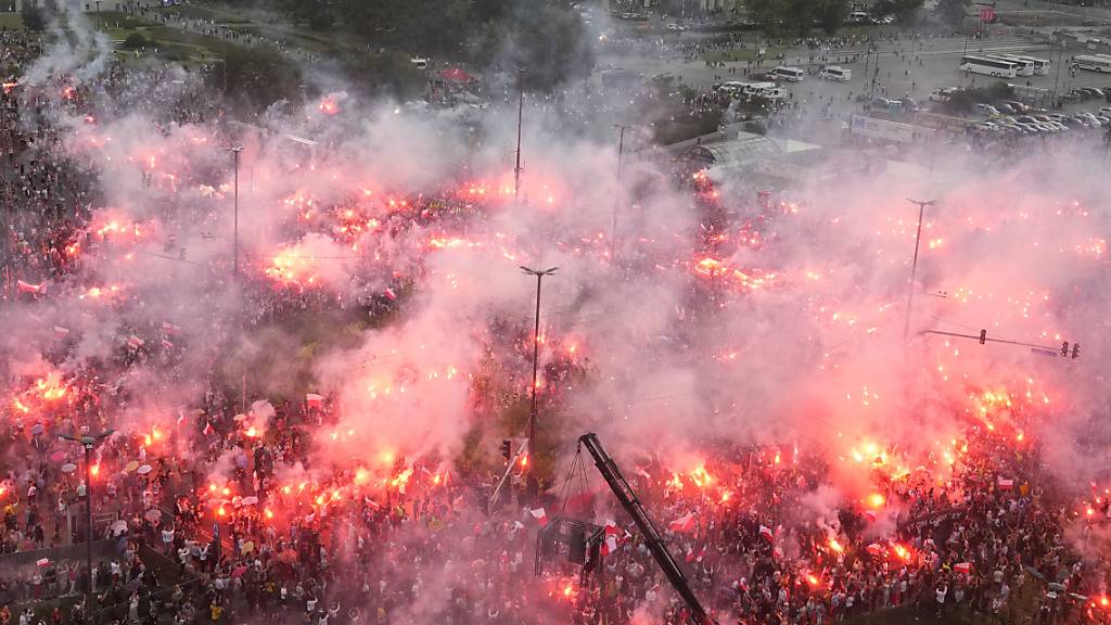 Menschen in Polen zünden Fackeln während der Feierlichkeiten zum 79. Jahrestag des Warschauer Aufstands. Foto: Czarek Sokolowski/AP/dpa