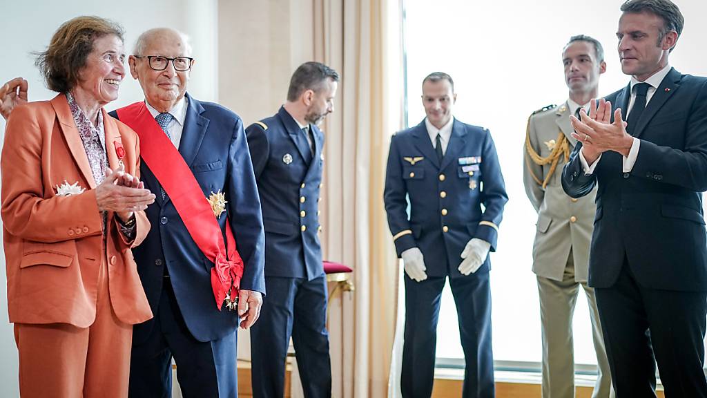 Emmanuel Macron (r), Präsident von Frankreich, zeichnet Beate und Serge Klarsfeld mit dem höchsten französischen Verdienstorden in der französischen Botschaft aus. Foto: Kay Nietfeld/dpa-Pool/dpa