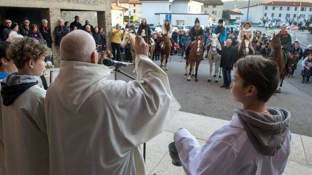 Pfarrer Don Olivero Bernasconi (Mitte) der Tessiner Gemeinde Genestrerio gibt Pferden und Hunden den Segen des Heiligen Antonius Abate, des Schutzpatrons der Nutztiere. (Archiv)