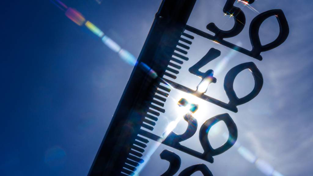 ARCHIV - Vor einem wolkenlosen blauen Himmel zeigt ein Außenthermometer bereits am Vormittag fast 30 Grad Lufttemperatur an. Die Temperatur steigt in den kommenden Tagen weiter. Foto: Jens Büttner/dpa