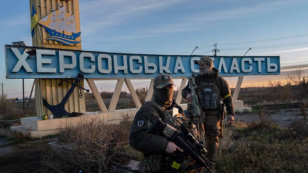 ARCHIV - Zwei ukrainische Soldaten stehen neben einem Schild mit der Aufschrift «Gebiet Cherson». Foto: Bernat Armangue/AP/dpa