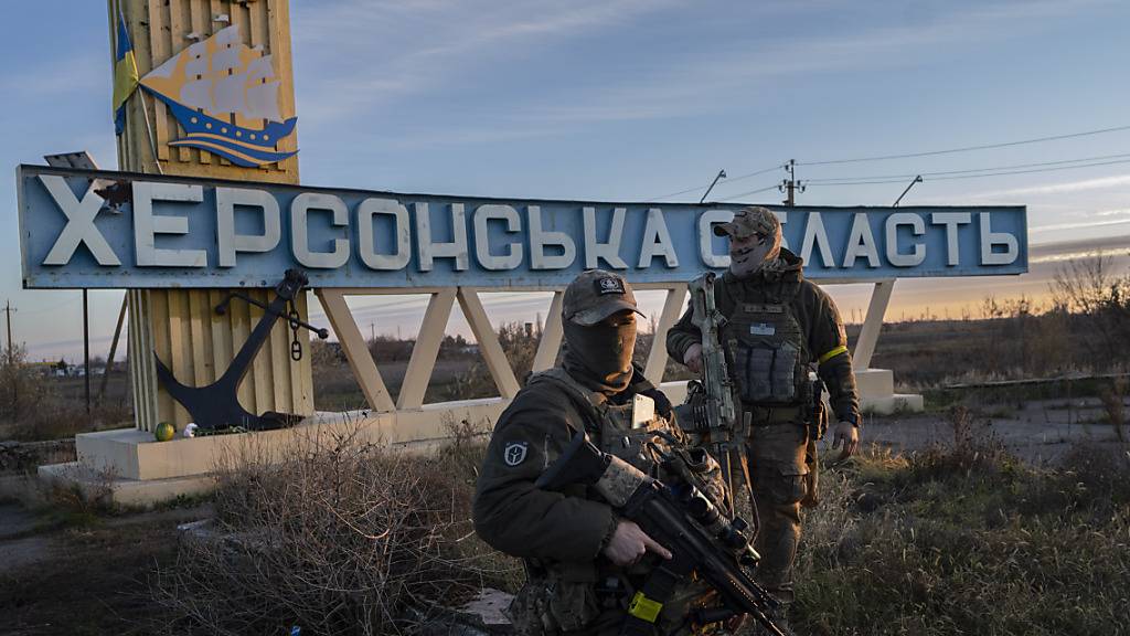ARCHIV - Zwei ukrainische Soldaten stehen neben einem Schild mit der Aufschrift «Gebiet Cherson». Foto: Bernat Armangue/AP/dpa