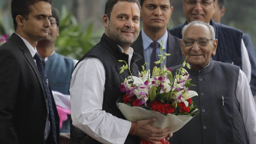 Rahul Gandhi (Mitte) mit Blumenstrauss - er führt künftig  Indiens Kongresspartei an.