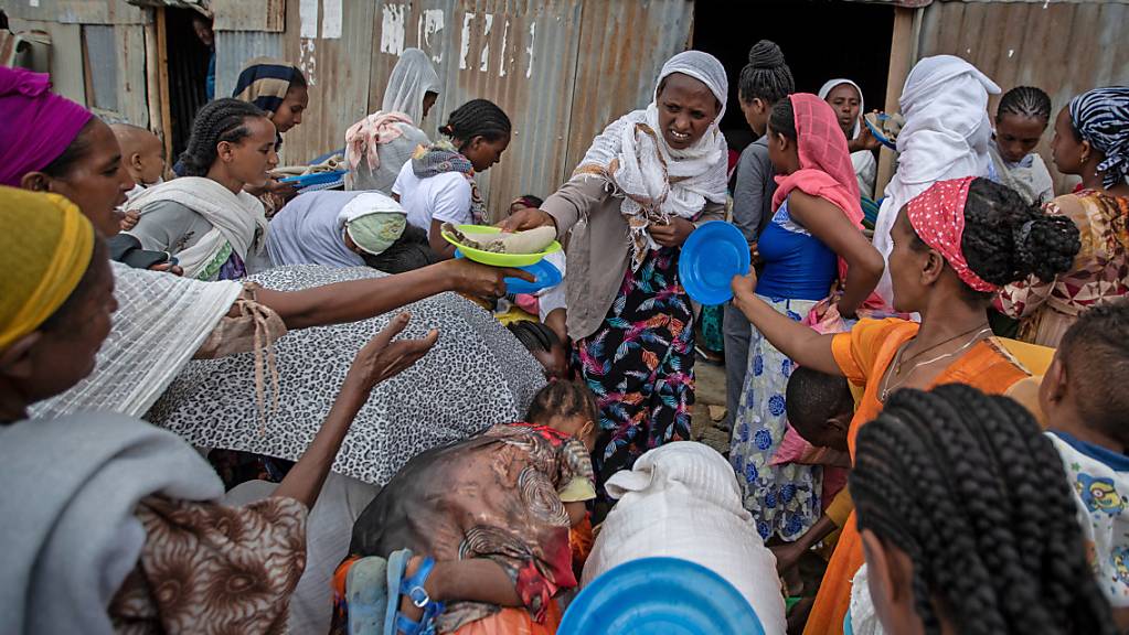 Vertriebene aus der Region Tigray stehen Schlange, um von Anwohnern gespendete Lebensmittel in einem Aufnahmezentrum für Binnenvertriebene zu erhalten.
