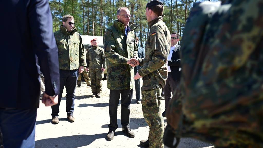 Bundeskanzler Friedrich Merz (CDU, M) und Lars Klingbeil (SPD, l), Vizekanzler und Bundesfinanzminister, verabschieden sich nach ihrem Besuch beim Heer in Munster. Foto: Philipp Schulze/dpa