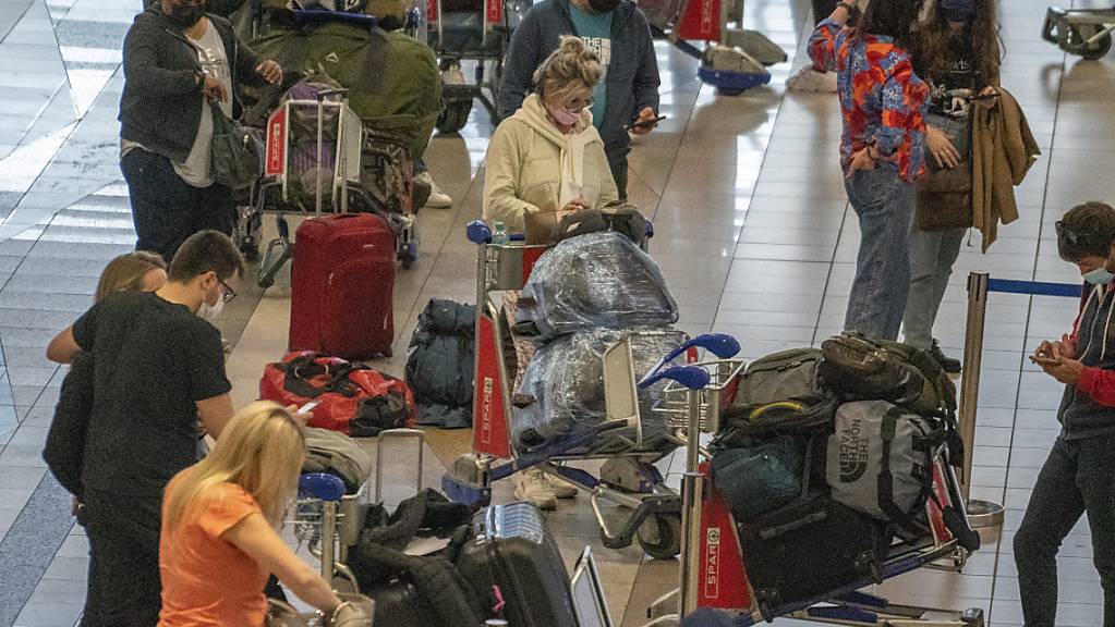 Menschen stellen sich auf dem Flughafen in Johannesburg für einen Air France-Flug nach Paris an. Die EU-Staaten wollen angesichts einer möglicherweise gefährlichen neuen Coronavirus-Variante die Passagierflüge aus sieben Ländern im südlichen Afrika aussetzen.
