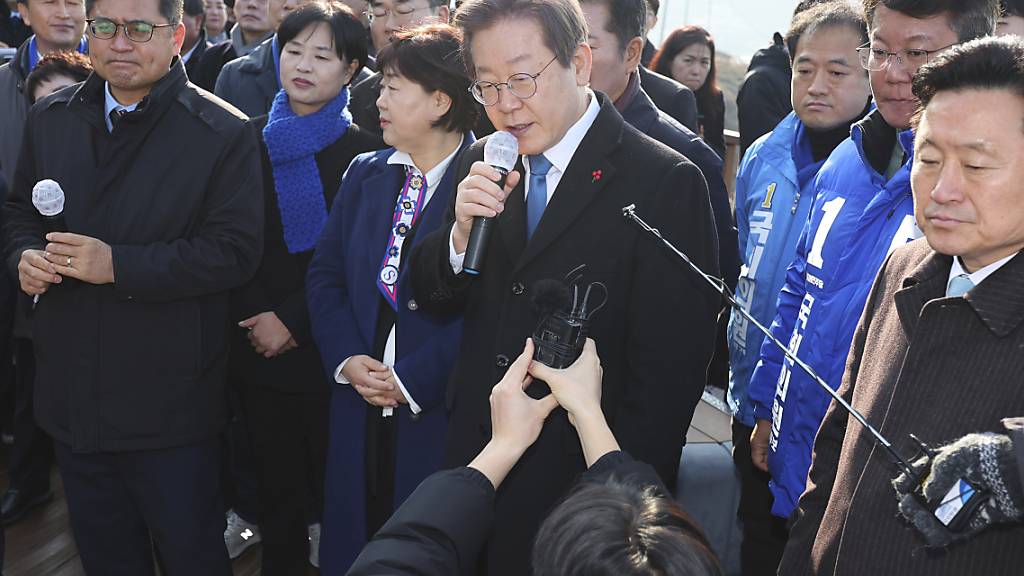 Südkoreas Oppositionschef Lee Jae Myung (M) spricht, während er die Baustelle eines neuen Flughafens besucht. Foto: Sohn Hyung-joo/YONHAP/AP/dpa - ACHTUNG: Nur zur redaktionellen Verwendung und nur mit vollständiger Nennung des vorstehenden Credits