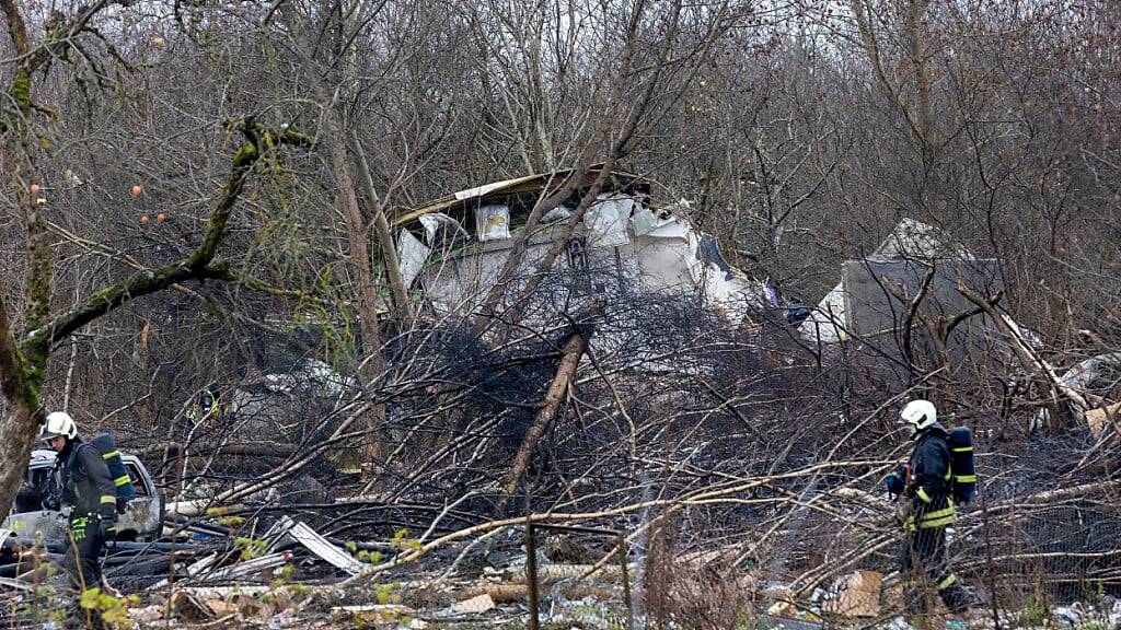 dpatopbilder - Mitarbeiter des litauischen Katastrophenschutzministeriums arbeiten in der Nähe der Absturzstelle. Foto: Mindaugas Kulbis/AP