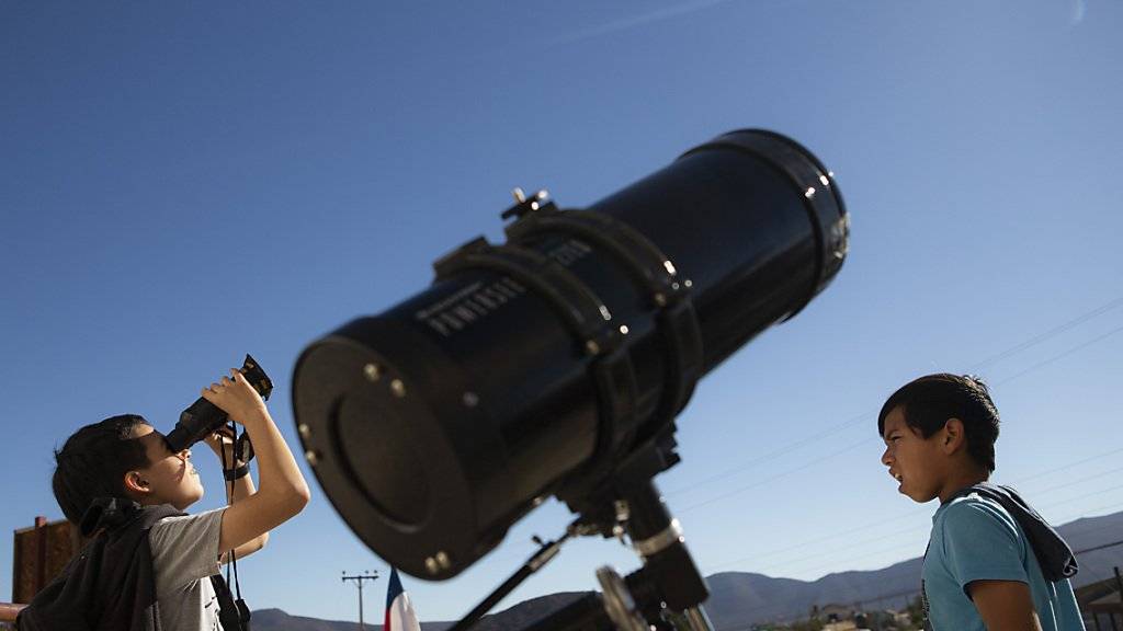 Auch Kinder in Chile testen Feldstecher, um die Sonnenfinsternis zu beobachten.