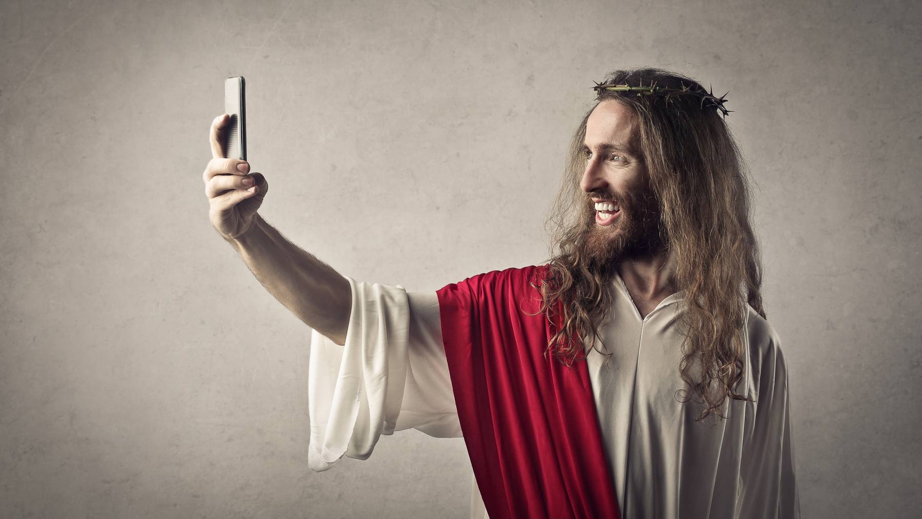 Jesus Christus hält Handy in der Hand