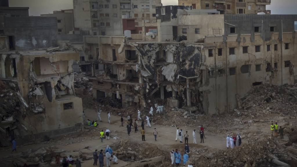 Menschen suchen nach Flutopfern. Auch Tage nach den schweren Überschwemmungen im Zuge des Sturms «Daniel» in Libyen sprechen internationale Helfer von einer «katastrophalen humanitären Lage» im Land. Foto: Ricardo Garcia Vilanova/AP/dpa