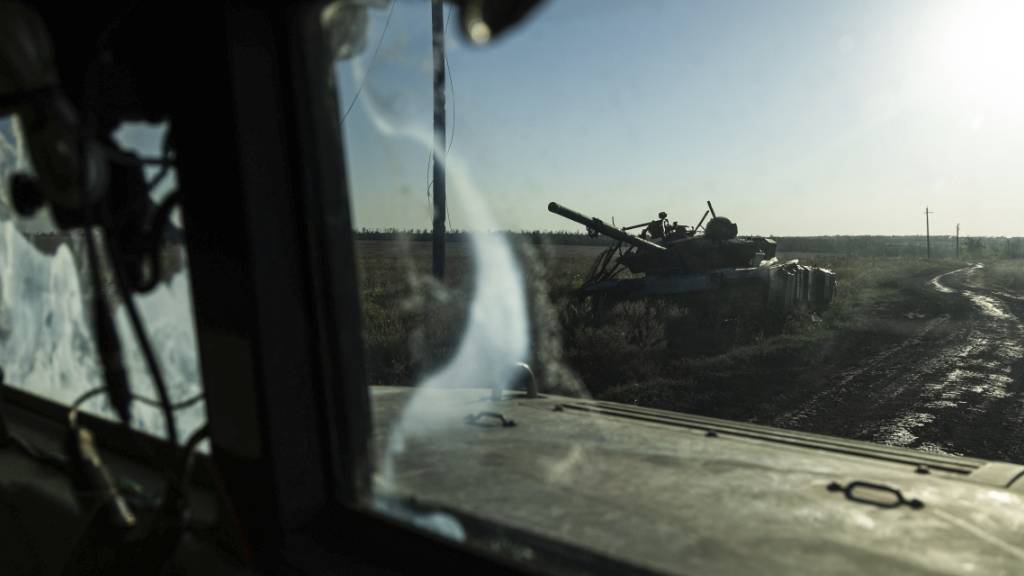 Ein zerstörter Panzer ist durch das Fenster eines Fahrzeugs an der Frontlinie in der Nähe von Klischtschijiwka bei Bachmut zu sehen. Foto: Alex Babenko/AP/dpa