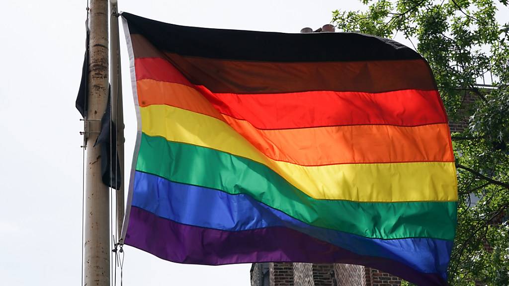 Eine Regenbogenflagge mit schwarzem und braunem Streifen zu Ehren der intersektionellen Diskriminierung gegenüber Schwarzen und Braunen Menschen innerhalb der LGBTQ Gemeinschaften weht am Stonewall National Monument. Foto: Bryan Smith/ZUMA Wire/dpa