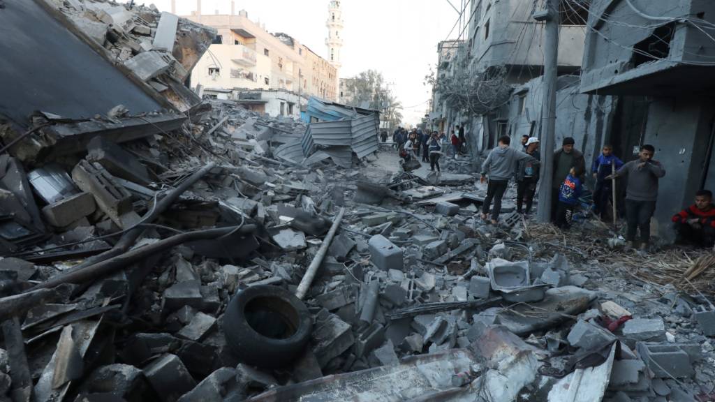 ARCHIV - Menschen begutachten Schäden und bergen in den Trümmern auf der Straße Gegenstände aus ihren Häusern nach israelischen Luftangriffen. Foto: Omar Ashtawy/APA Images via ZUMA Press Wire/dpa