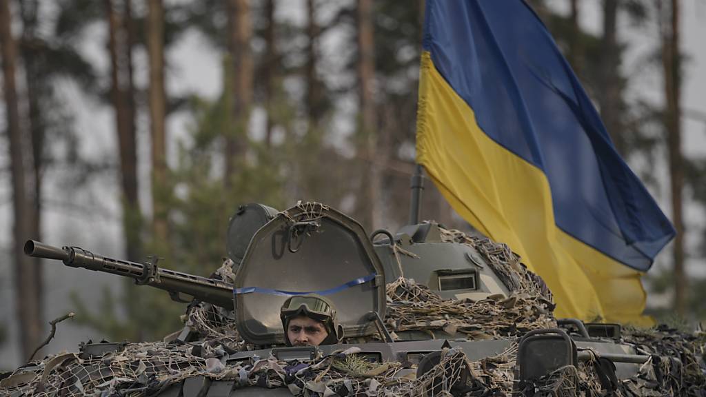 Die ukrainische Flagge ist an einem Radschützenpanzer bei Kiew angebracht. Foto: Vadim Ghirda/AP/dpa