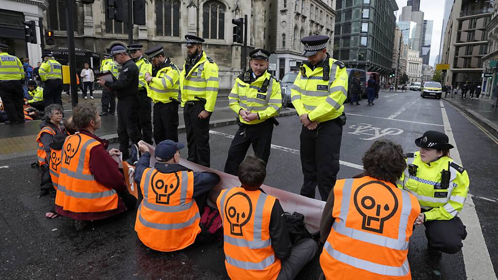ARCHIV - Aktivisten der Gruppe «Just Stop Oil» blockieren im Oktober eine Straße und fordern, zukünftige Gas- und Ölprojekte zu verhindern. Foto: Kirsty Wigglesworth/AP/dpa