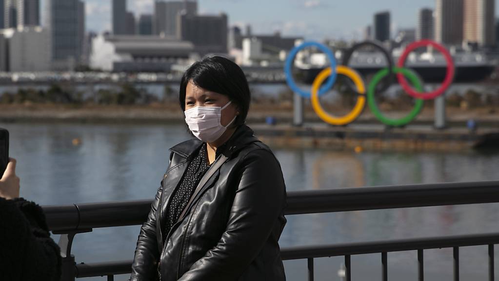 Schutzmaske und olympische Ringe: Tokio bangt um die Olympischen Spiele.
