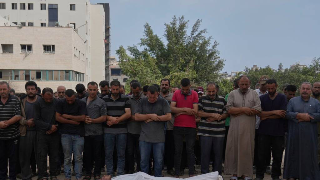 Palästinenser beten im Schifa-Krankenhaus in Gaza-Stadt an der Leiche eines Menschen, der bei dem Versuch getötet wurde, Hilfsgütertransporter zu erreichen, die über den israelischen Grenzübergang Zikim in den nördlichen Gazastreifen einfuhren. Foto: Abdel Kareem Hana/AP/dpa