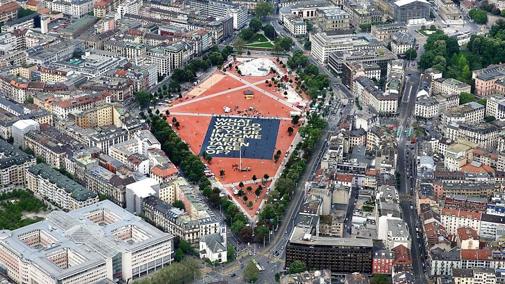 Das grösste Plakat der Welt wirbt für ein bedingungsloses Grundeinkommen: Aus der Helikopterperspektive sieht die 8000 Quadratmeter grosse  Affiche auf der Plaine de Plainpalais in Genf winzig klein aus.