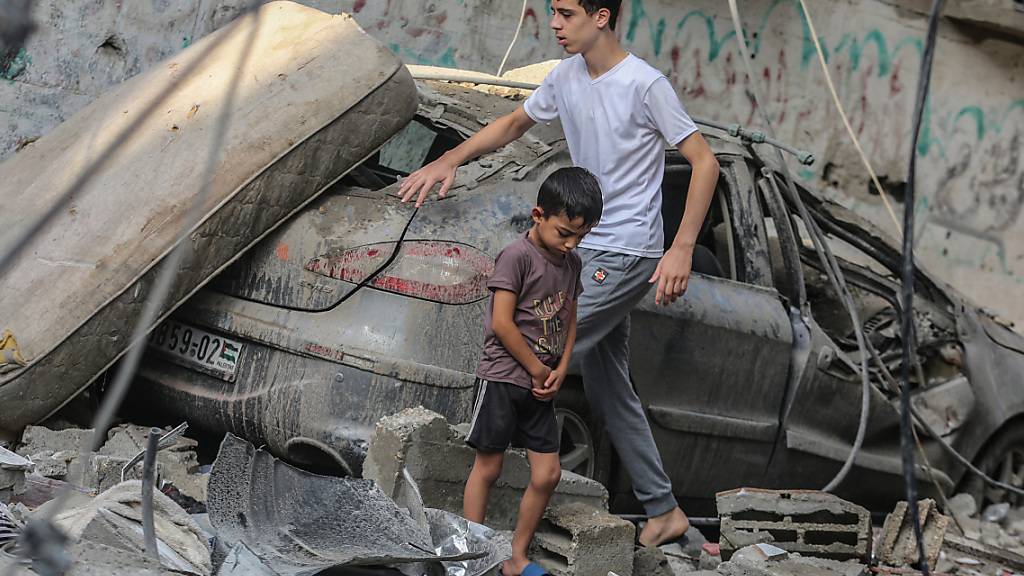 dpatopbilder - Junge Palästinenser laufen im Morgengrauen durch die Trümmer von Gebäuden, die bei israelischen Luftangriffen zerstört wurden. Foto: Mohammed Talatene/dpa
