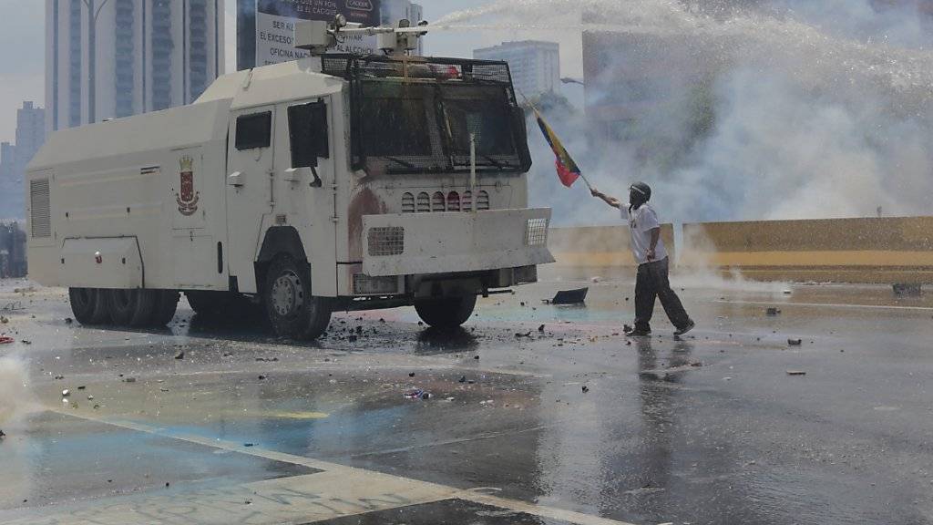 Kampf gegen Wasserwerfer: Ein Regierungsgegner demonstriert in Venezuelas Hauptstadt Caracas - bei den Protesten sterben zwei weitere junge Männer.