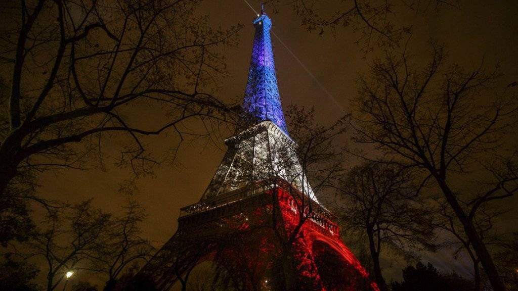 Im Gedenken an die 130 Todesopfer der Anschläge vom 13. November lässt Paris den Eiffelturm als Tricolore erstrahlen.
