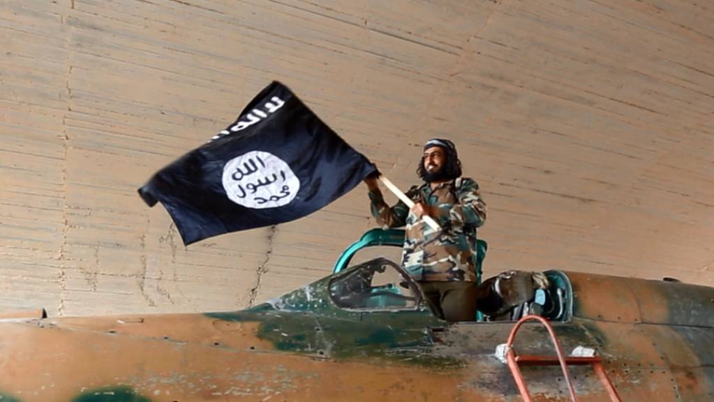 Ein Kämpfer der Terrormiliz Islamischer Staat schwenkt eine IS-Fahne in Syrien. (Archivbild)
