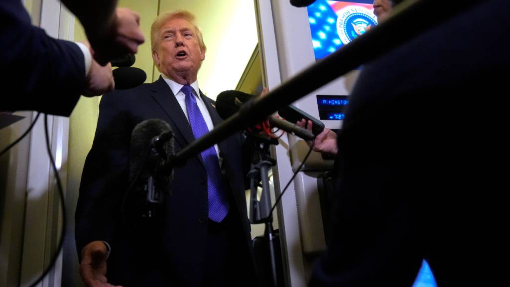 US-Präsident Donald Trump spricht zu Reportern, während er an Bord der Air Force One von der Joint Base Andrews nach West Palm Beach fliegt. Foto: Mark Schiefelbein/AP/dpa