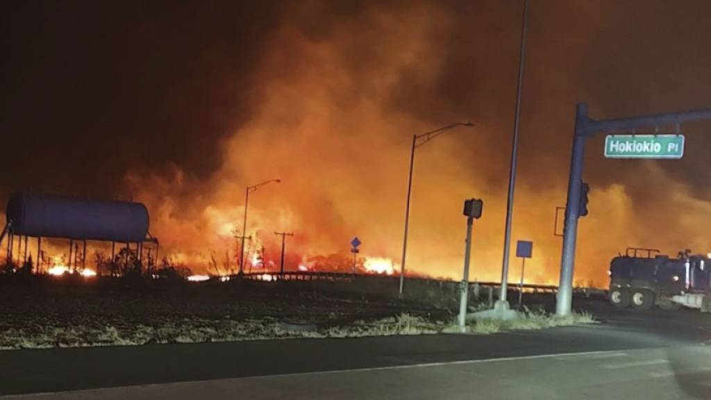 ARCHIV - Dieses von der Nachrichtenagentur AP am 15.08.2023 zur Verfügung gestellte Foto zeigt zeigt Feuer und Rauch an der Kreuzung Hokiokio Place und Lahaina Bypass. Die Wald- und Buschbrände waren am 8. August an mehreren Orten auf Maui und der Nachbarinsel Hawaii ausgebrochen. Foto: Zeke Kalua/County of Maui/AP/dpa