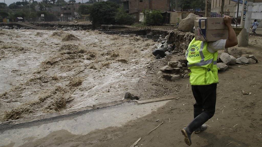 Helfer versorgen Menschen, die in der Nähe Limas durch Überschwemmungen und Erdrutsche isoliert wurden. Eine rätselhafte Meerwassererwärmung vor der peruanischen Küste hat die Katastrophen ausgelöst.